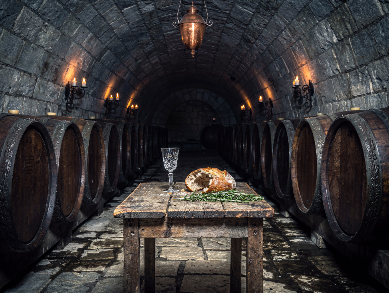Vaulted stone wine cellar with oak barrels